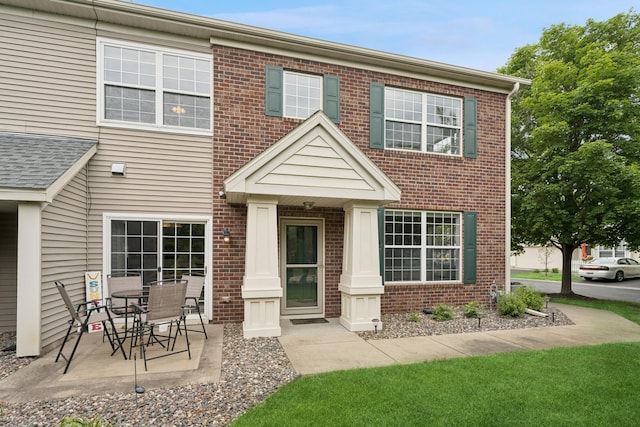 12245 Urbank St NE Unit E, Blaine, MN 55449 - view of front of property featuring brick siding and a patio