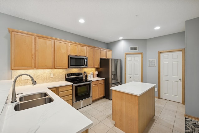 12245 Urbank St NE Unit E, Blaine, MN 55449 - kitchen with stainless steel appliances, a sink, a kitchen island, backsplash, and light tile patterned floors