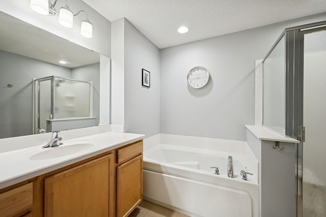 12245 Urbank St NE Unit E, Blaine, MN 55449 - full bath with a shower stall, a garden tub, vanity, tile patterned flooring, and a textured ceiling