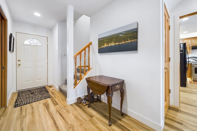 foyer featuring light wood-style floors, stairs, baseboards, and recessed lighting