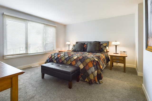 carpeted bedroom featuring multiple windows and baseboards