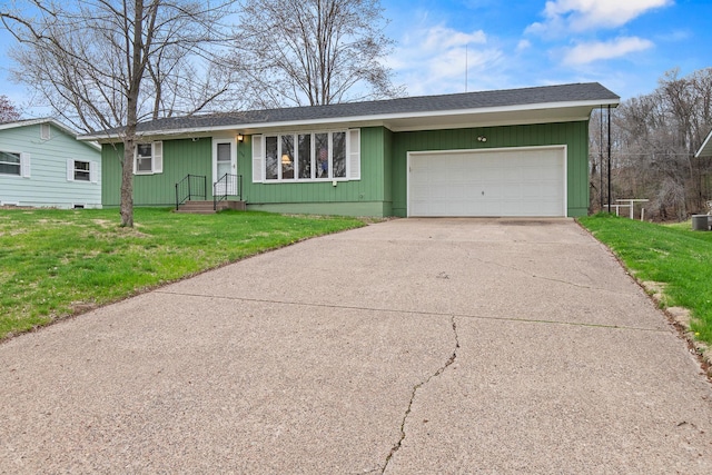 ranch-style home featuring concrete driveway, roof with shingles, an attached garage, and a front yard