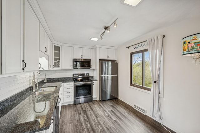kitchen with a sink, stainless steel appliances, tasteful backsplash, visible vents, and white cabinets