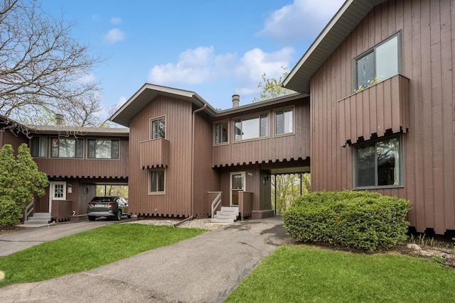 view of front facade featuring entry steps, aphalt driveway, and a carport