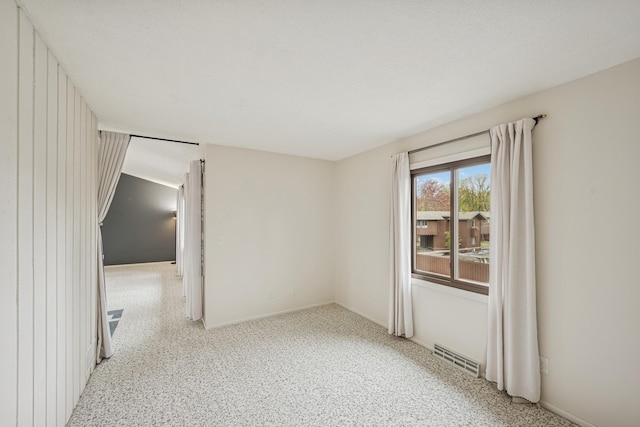 spare room with baseboards and visible vents