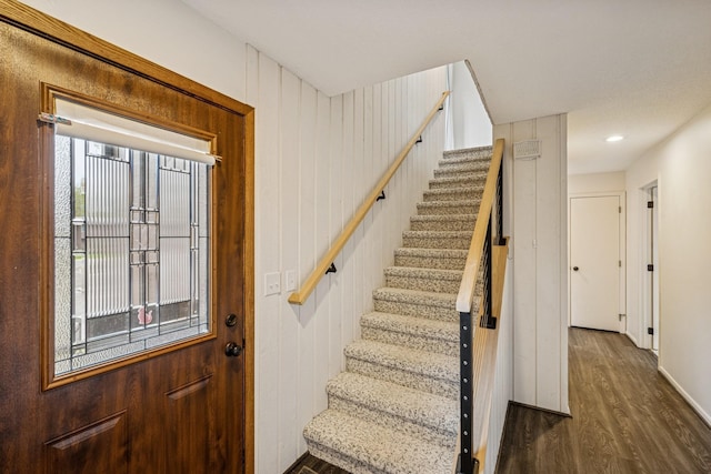 staircase with baseboards and wood finished floors