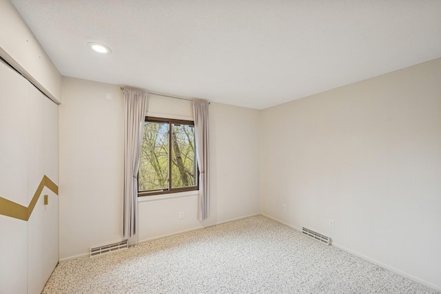 empty room featuring visible vents, baseboards, and recessed lighting