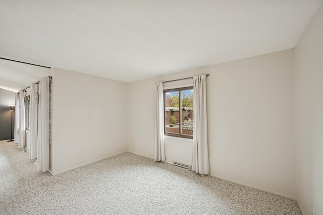spare room featuring baseboards and visible vents