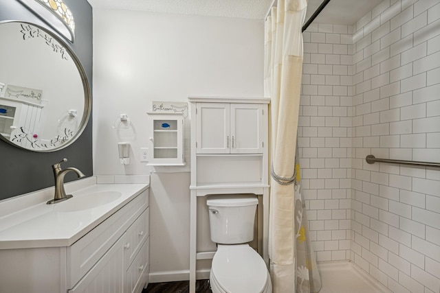 bathroom featuring toilet, vanity, and a tile shower