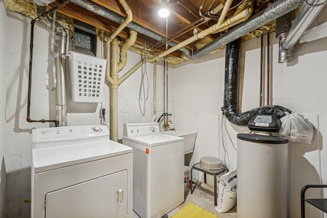 clothes washing area featuring separate washer and dryer, laundry area, and a sink