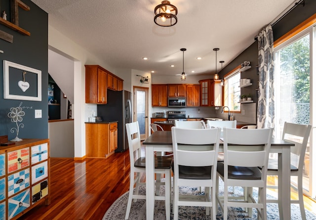 dining area featuring dark wood-type flooring, recessed lighting, and a textured ceiling