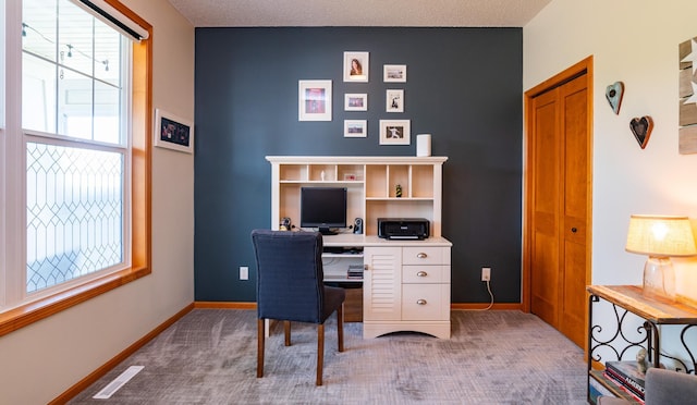 carpeted home office with plenty of natural light and baseboards