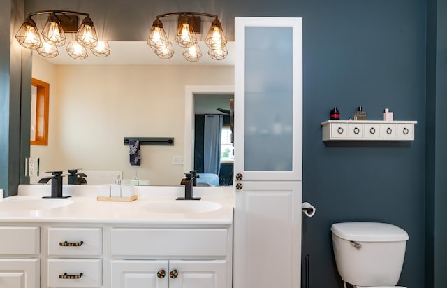 bathroom featuring a chandelier, double vanity, ensuite bath, and toilet