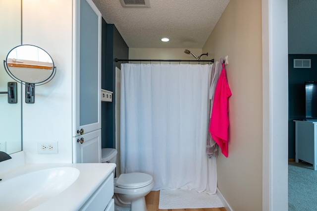 full bath featuring a textured ceiling, curtained shower, toilet, and vanity