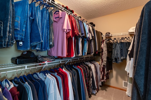 walk in closet with carpet floors
