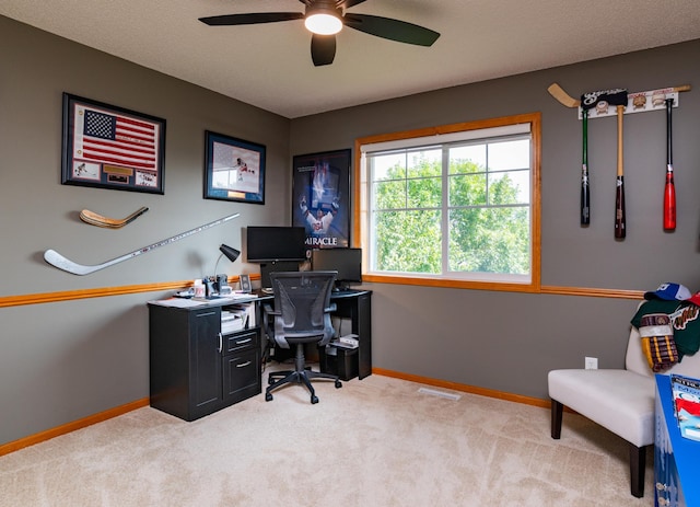 carpeted office featuring baseboards and ceiling fan