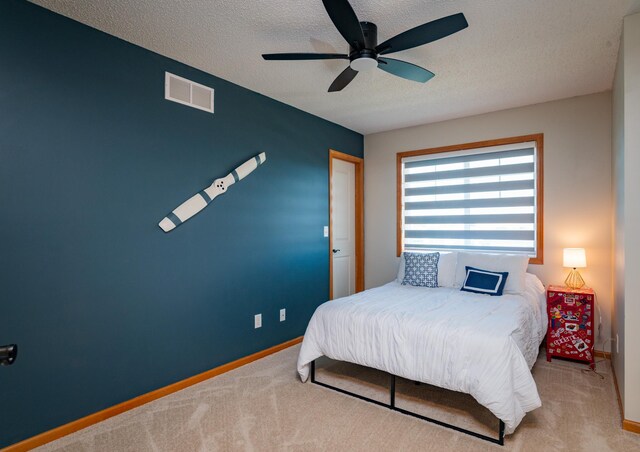 bedroom with carpet flooring, a textured ceiling, baseboards, and ceiling fan