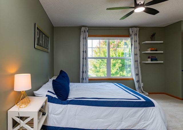 bedroom featuring carpet, a textured ceiling, a ceiling fan, and baseboards
