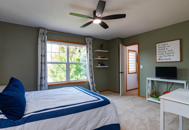 carpeted bedroom featuring a textured ceiling, baseboards, and a ceiling fan