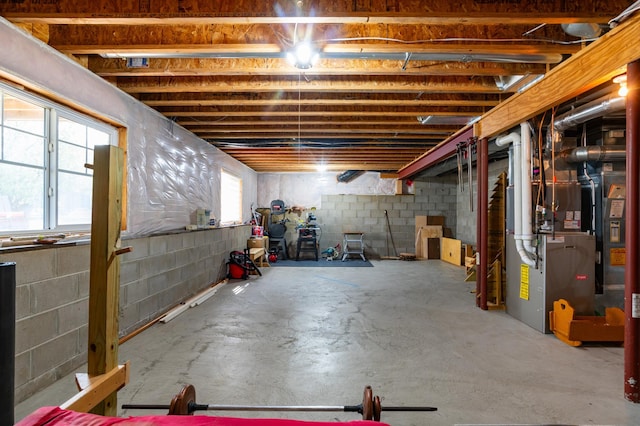 basement featuring heating unit and concrete block wall