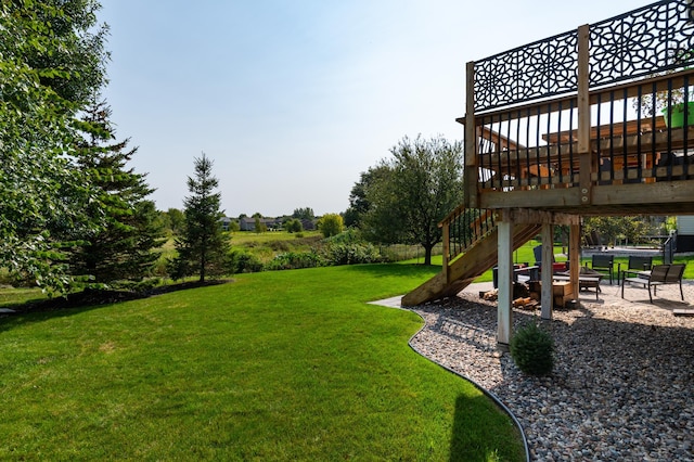 view of green lawn featuring a patio area and a deck
