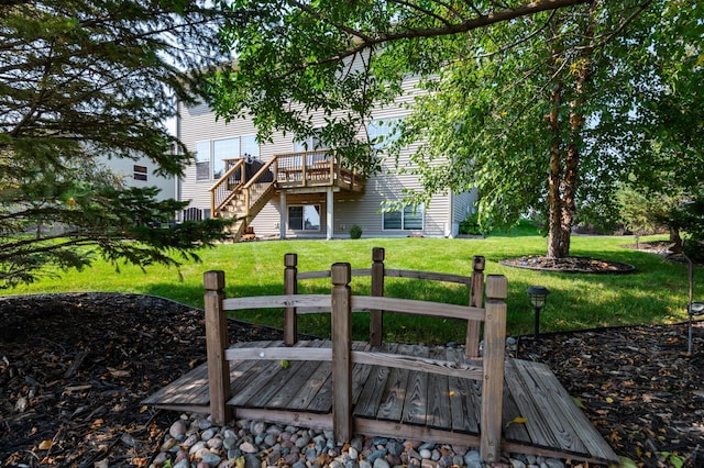 back of property featuring a wooden deck, a lawn, and stairway