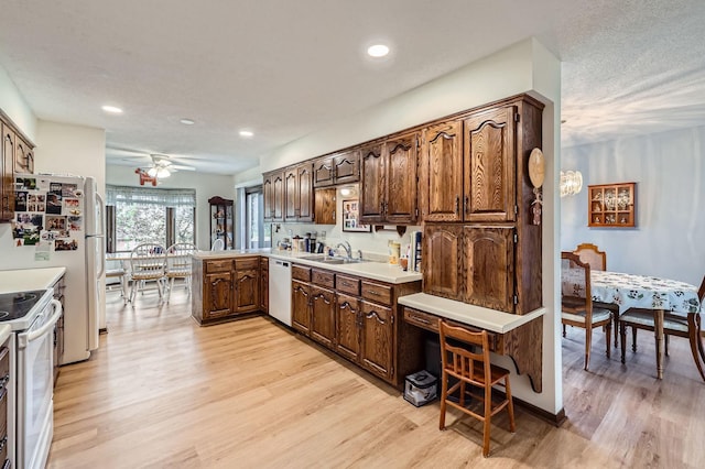 792 Gramsie Rd, Shoreview, MN 55126 - kitchen with white appliances, a sink, light wood-style floors, ceiling fan, and a peninsula