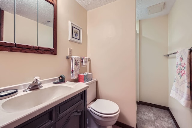 792 Gramsie Rd, Shoreview, MN 55126 - bathroom with a textured ceiling, toilet, vanity, baseboards, and stone finish flooring