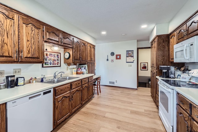 792 Gramsie Rd, Shoreview, MN 55126 - kitchen with white appliances, a sink, light wood finished floors, light countertops, and recessed lighting