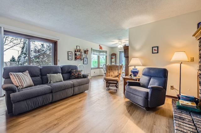 792 Gramsie Rd, Shoreview, MN 55126 - living room featuring light wood finished floors, a textured ceiling, baseboards, and ceiling fan