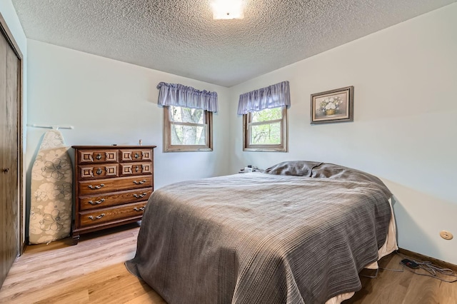 792 Gramsie Rd, Shoreview, MN 55126 - bedroom with light wood-style flooring, a textured ceiling, and a closet