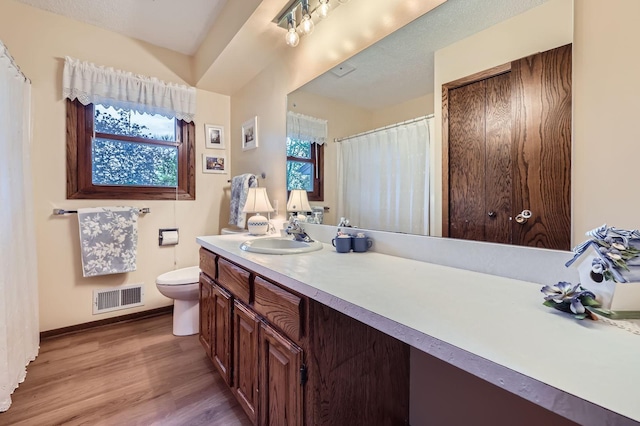 792 Gramsie Rd, Shoreview, MN 55126 - full bathroom with wood finished floors, toilet, vanity, and baseboards