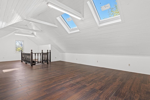 bonus room featuring lofted ceiling with skylight and wood finished floors