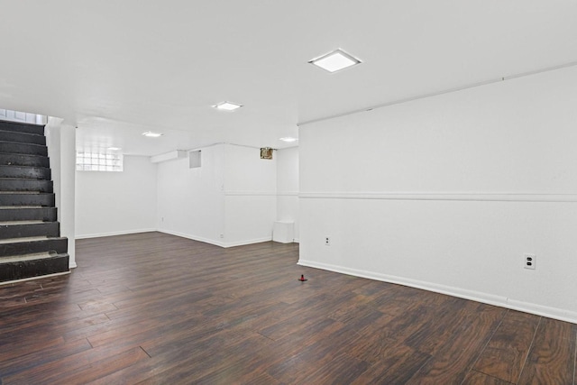 below grade area with stairway, wood finished floors, and baseboards
