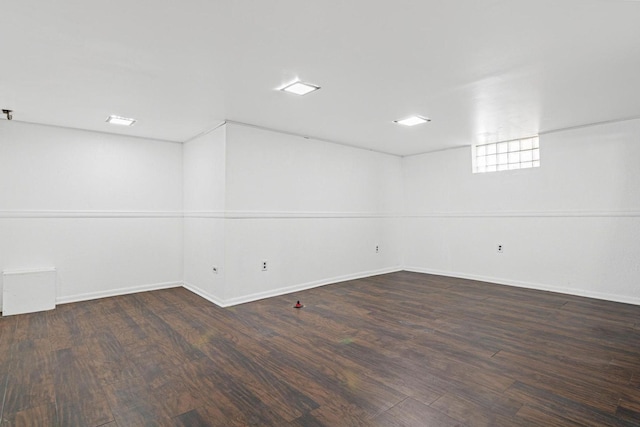 basement featuring baseboards and wood finished floors