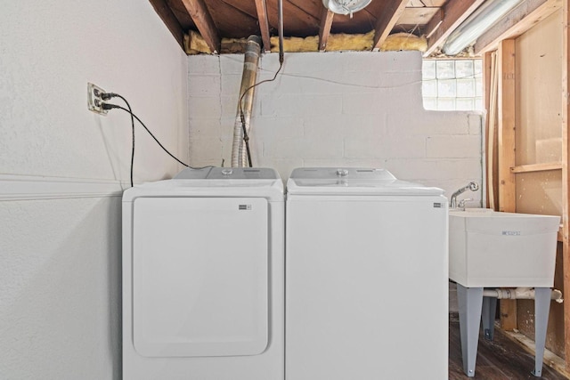 laundry area with washing machine and clothes dryer, laundry area, and concrete block wall