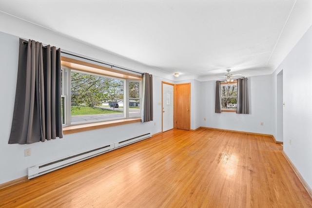 600 Mclean St, Mora, MN 55051 - unfurnished living room featuring a baseboard heating unit, wood finished floors, healthy amount of natural light, and ceiling fan