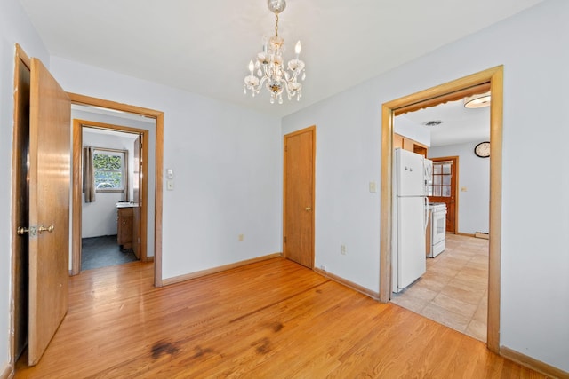 600 Mclean St, Mora, MN 55051 - unfurnished dining area featuring a chandelier, light wood-style floors, and baseboards