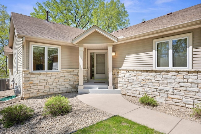 10715 57th Ave N, Plymouth, MN 55442 - doorway to property with stone siding, roof with shingles, and cooling unit
