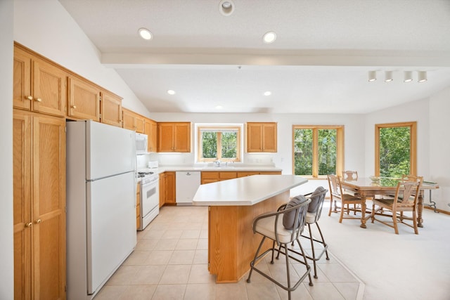 10715 57th Ave N, Plymouth, MN 55442 - kitchen with white appliances, a sink, light countertops, lofted ceiling, and a kitchen breakfast bar