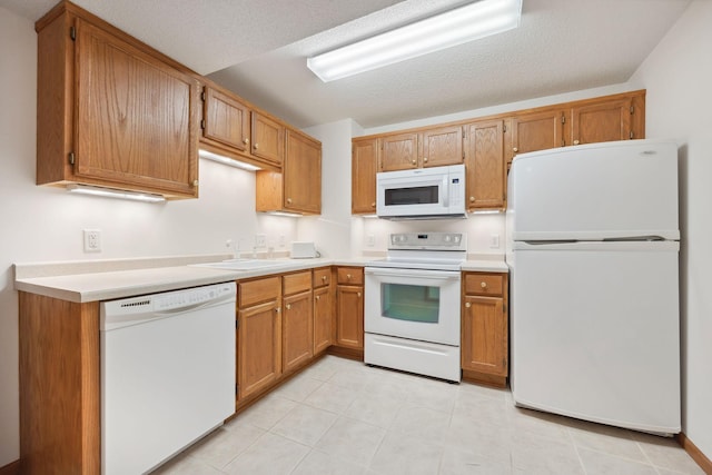 10715 57th Ave N, Plymouth, MN 55442 - kitchen with white appliances, a sink, light countertops, light tile patterned flooring, and brown cabinetry