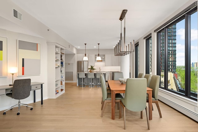dining area featuring light wood-style flooring, healthy amount of natural light, baseboard heating, recessed lighting, and a desk
