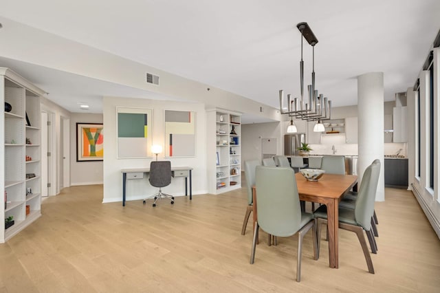 dining area with light wood-type flooring, baseboards, and built in features
