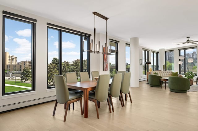 dining room with light wood finished floors, plenty of natural light, and baseboard heating