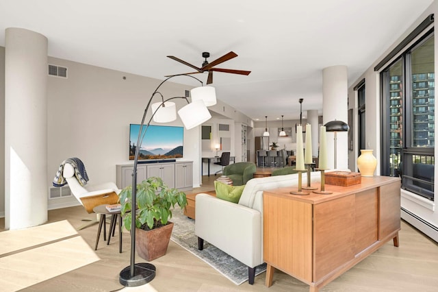 living area featuring ceiling fan, light wood-style floors, and a baseboard radiator