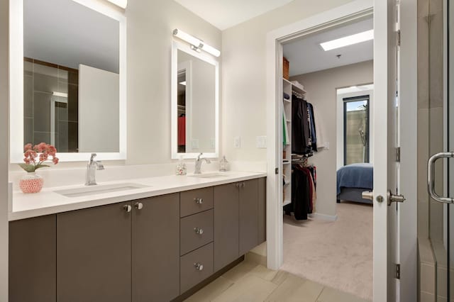 full bath featuring a shower stall, double vanity, and a walk in closet