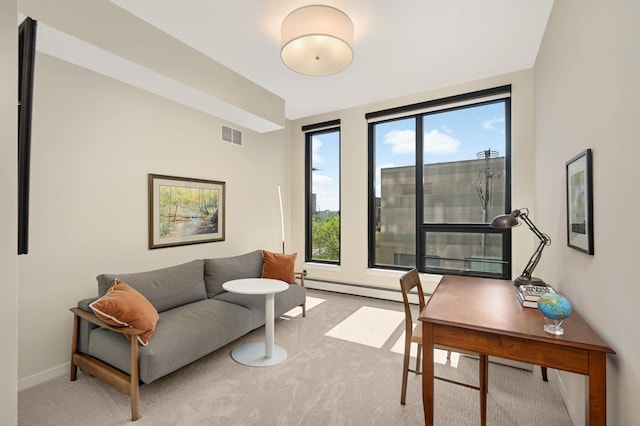 office area featuring light carpet, baseboard heating, and baseboards