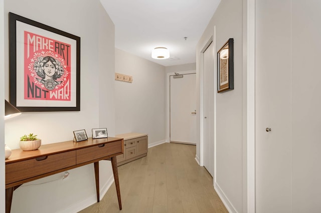 hallway with light wood-style floors and baseboards
