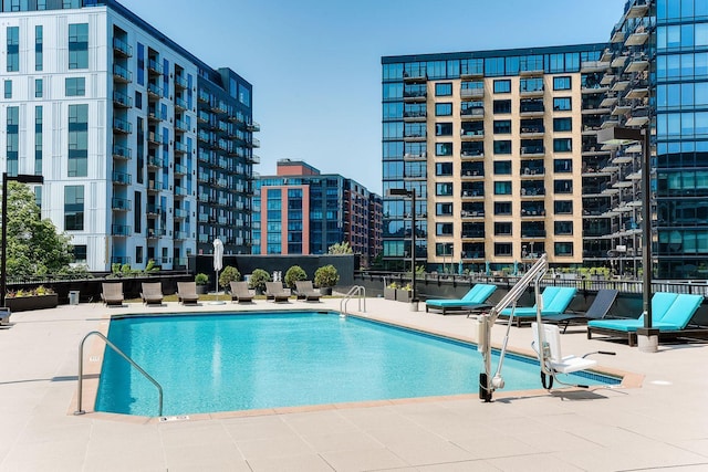 community pool with a city view and a patio