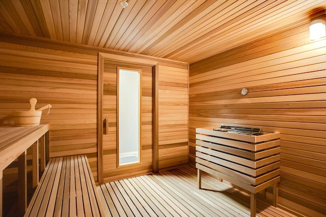 relaxing sauna featuring wood walls and wooden ceiling